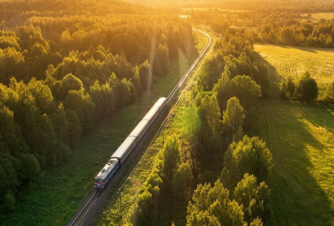 Trein die door een bos rijdt, wat staat voor verbeterde koeling en spoorprestaties.
