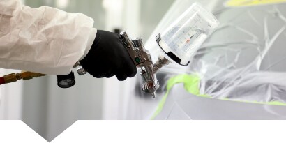 Spuiter brengt lak aan op een gerepareerd autopaneel
