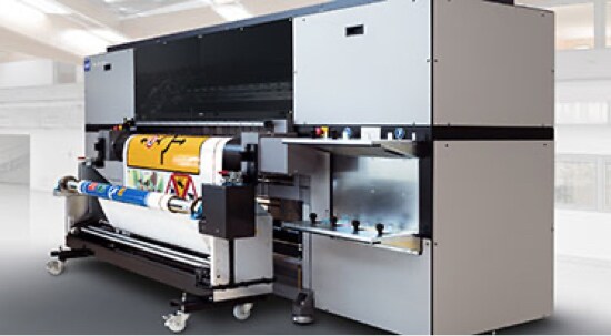 Een grote, grijze, digitale printer voor borden waarmee een verkeersbord wordt afgedrukt.