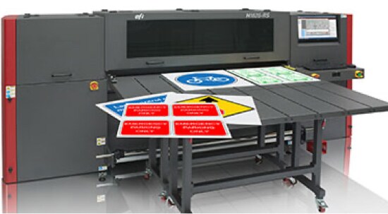 Een donkergrijze, digitale printer voor borden, met gedrukte borden op het vlakbed.
