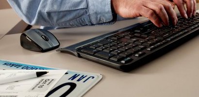 Hands on keyboard and license plate on desk
