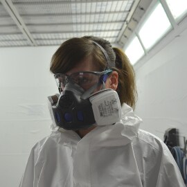 Persoon die persoonlijke beschermingsmiddelen draagt in de spuitcabine