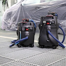 Afbeelding van twee Clean Sanding-systemen in een carrosseriewerkplaats