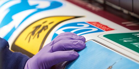 Persoon die folie voor verkeersbord bedrukt
